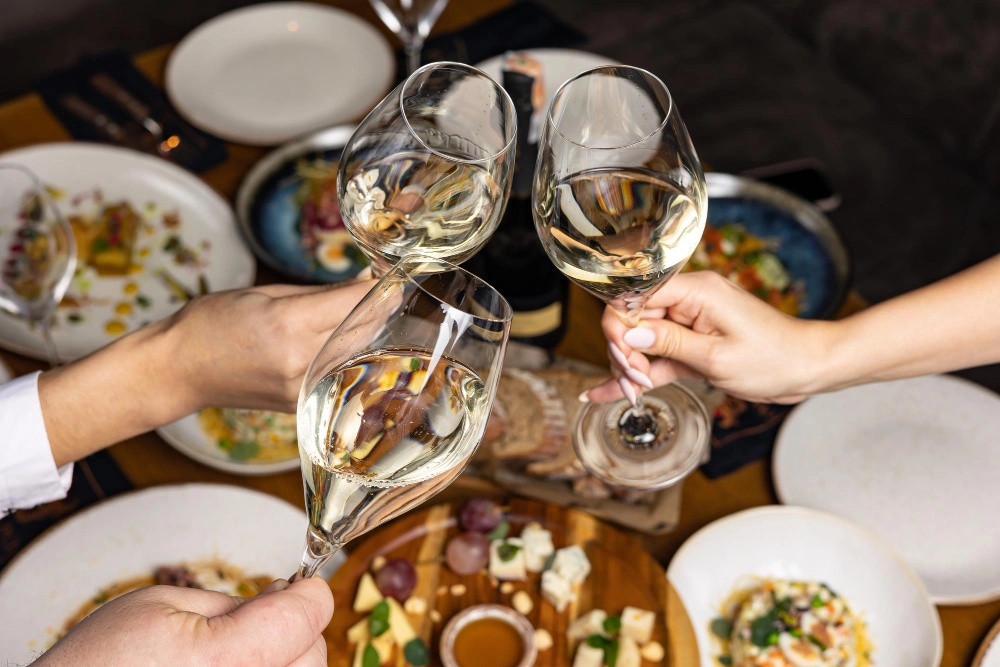 trois personnes trinque pendant leur repas